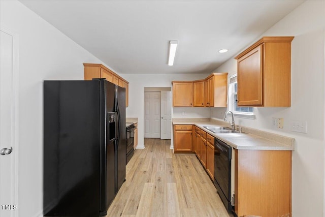 kitchen with black appliances, a sink, light wood-style flooring, light countertops, and recessed lighting