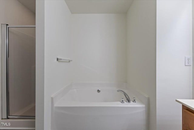 bathroom featuring vanity, a bath, and a stall shower