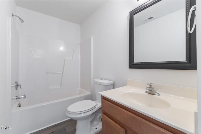 bathroom with toilet, vanity, wood finished floors, and shower / bath combination