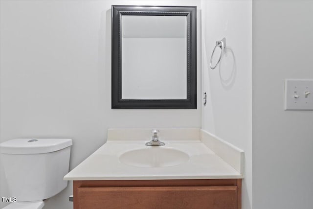 half bath featuring vanity and toilet