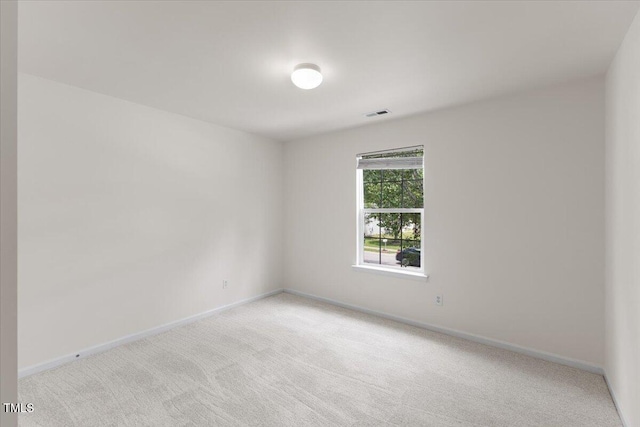 spare room with light carpet and baseboards