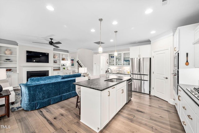 829 Churton Pl, Cary, NC 27518 - kitchen featuring a sink, appliances with stainless steel finishes, crown molding, ceiling fan, and a fireplace