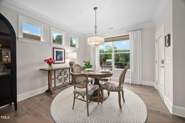 829 Churton Pl, Cary, NC 27518 - dining area with crown molding, baseboards, a chandelier, and wood finished floors