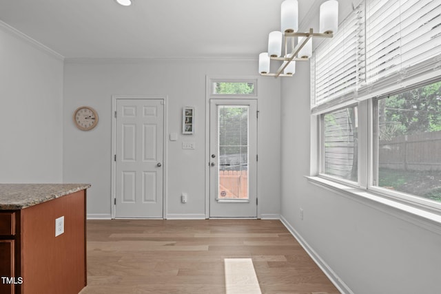 3204 Plaza Pl, Raleigh, NC 27612 - unfurnished dining area with a chandelier, crown molding, and light wood-type flooring
