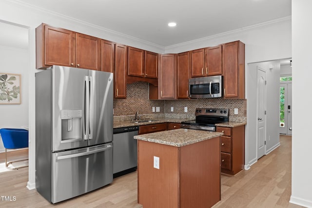 3204 Plaza Pl, Raleigh, NC 27612 - kitchen featuring appliances with stainless steel finishes, light wood finished floors, backsplash, a kitchen island, and crown molding