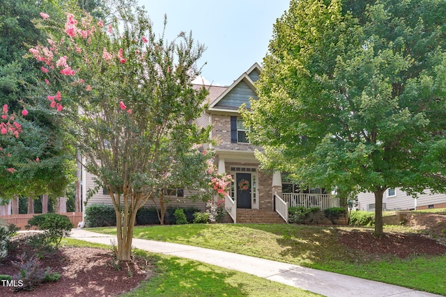 3204 Plaza Pl, Raleigh, NC 27612 - view of property hidden behind natural elements with a front yard, a porch, and brick siding