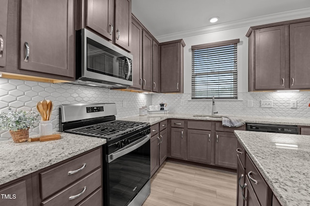 125 Shadowdale Ln, Rolesville, NC 27571 - kitchen featuring stainless steel appliances, dark brown cabinetry, crown molding, light stone countertops, and light wood-style floors