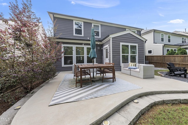 rear view of house featuring fence, a patio, and outdoor dining area