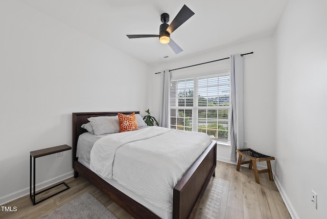 bedroom featuring light wood-style flooring, baseboards, and ceiling fan