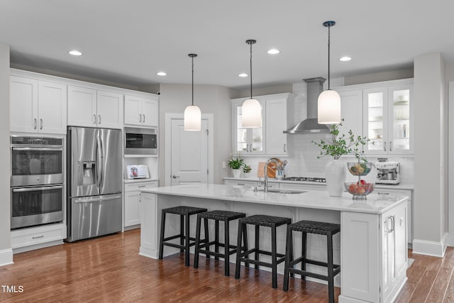 2711 Jordan Pointe Blvd, New Hill, NC 27562 - kitchen featuring stainless steel appliances, wall chimney exhaust hood, white cabinetry, a sink, and backsplash