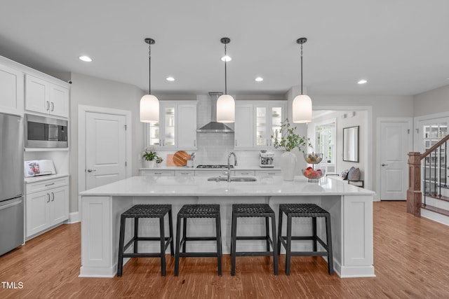 2711 Jordan Pointe Blvd, New Hill, NC 27562 - kitchen featuring wall chimney range hood, a sink, stainless steel appliances, white cabinetry, and glass insert cabinets