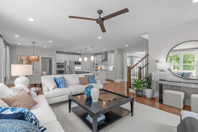 2711 Jordan Pointe Blvd, New Hill, NC 27562 - living area featuring light wood finished floors, a ceiling fan, recessed lighting, baseboards, and stairs