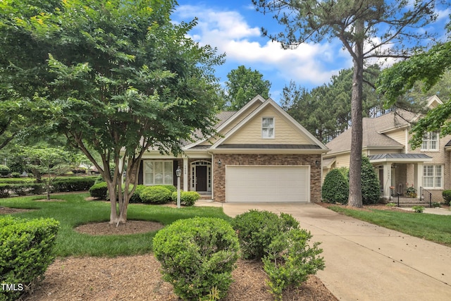 view of front of property with driveway, a front yard, a garage, and brick siding