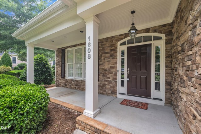 property entrance with stone siding and a porch