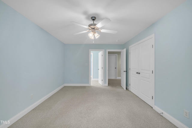 spare room with light carpet, baseboards, and a ceiling fan