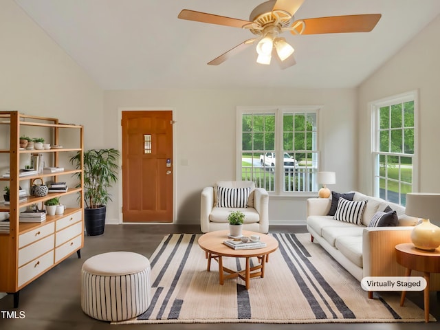 living area featuring lofted ceiling, healthy amount of natural light, a ceiling fan, wood finished floors, and baseboards