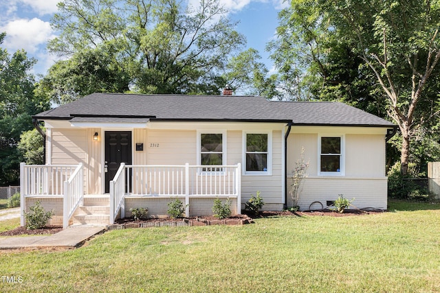 ranch-style house featuring roof with shingles, covered porch, and a chimney