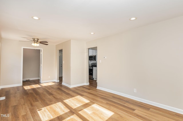 empty room with light wood-style flooring, a ceiling fan, recessed lighting, and baseboards