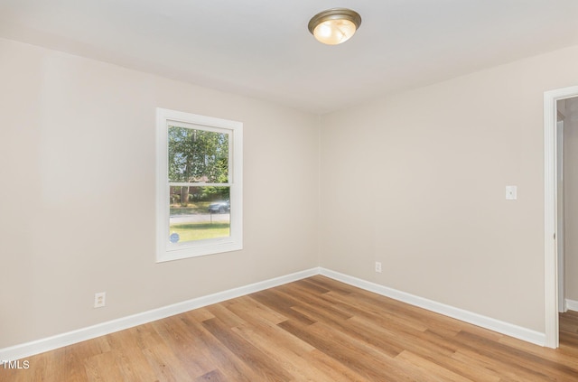empty room featuring baseboards and light wood-type flooring