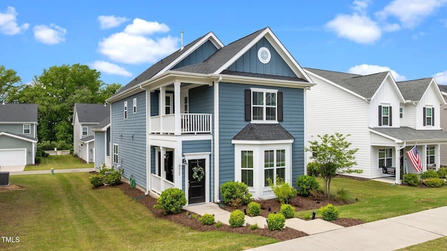 8925 Lee Brown Ridge Dr, Wake Forest, NC 27587 - view of front of home featuring board and batten siding, a balcony, a front yard, and roof with shingles