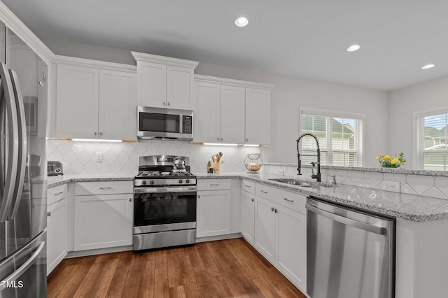 8925 Lee Brown Ridge Dr, Wake Forest, NC 27587 - kitchen with appliances with stainless steel finishes, a sink, a peninsula, white cabinetry, and dark wood finished floors