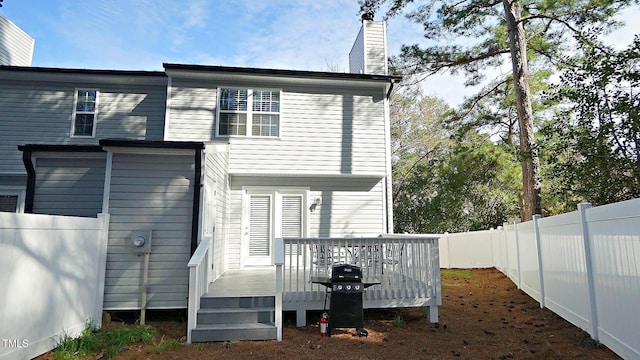 4613 Nesbit Ct, Raleigh, NC 27616 - rear view of property with a deck, a fenced backyard, and a chimney