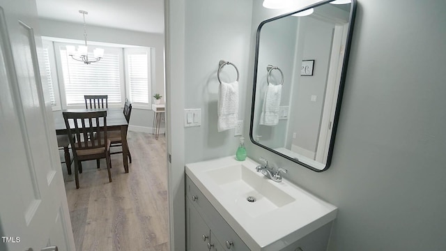 4613 Nesbit Ct, Raleigh, NC 27616 - bathroom with wood finished floors, a chandelier, and vanity