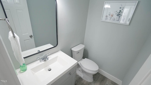 4613 Nesbit Ct, Raleigh, NC 27616 - bathroom with toilet, vanity, wood finished floors, and baseboards