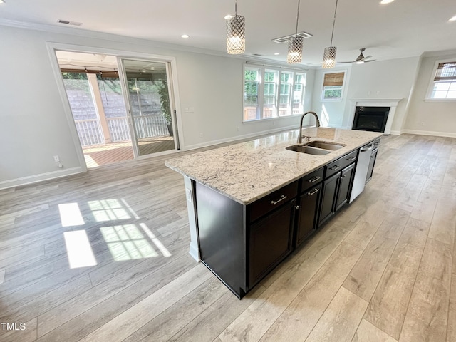 8813 Moss Glen Dr, Raleigh, NC 27617 - kitchen with a sink, open floor plan, a fireplace, light wood finished floors, and crown molding