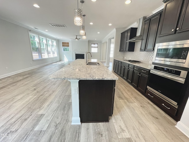 8813 Moss Glen Dr, Raleigh, NC 27617 - kitchen with appliances with stainless steel finishes, a sink, ornamental molding, open floor plan, and light wood-style floors