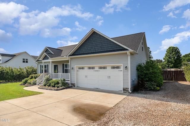 craftsman-style home featuring driveway, covered porch, a garage, and a shingled roof