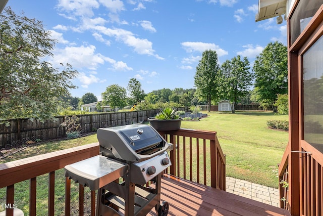 deck with a shed, an outbuilding, and a grill