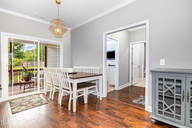dining area with ornamental molding, a chandelier, wood finished floors, and baseboards