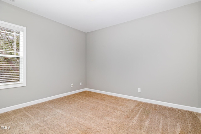empty room featuring carpet floors and baseboards