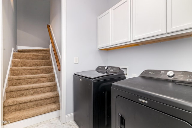 laundry room with washing machine and dryer, cabinet space, marble finish flooring, and baseboards