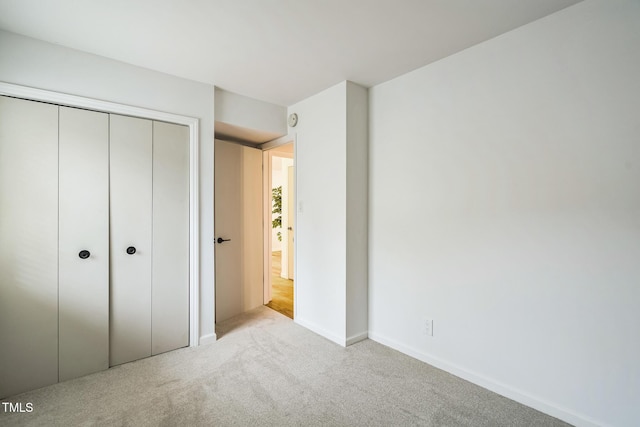 unfurnished bedroom with carpet floors, a closet, and baseboards