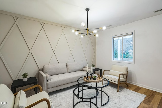 living area with wood finished floors, a chandelier, and baseboards