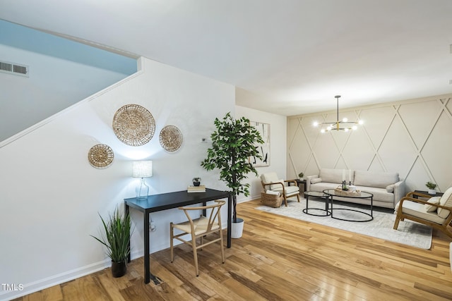 living room featuring a chandelier, hardwood / wood-style floors, and baseboards