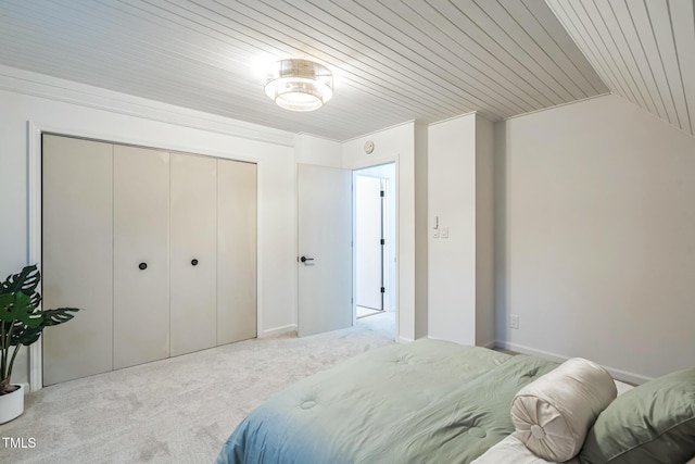 carpeted bedroom with a closet, wooden ceiling, and lofted ceiling