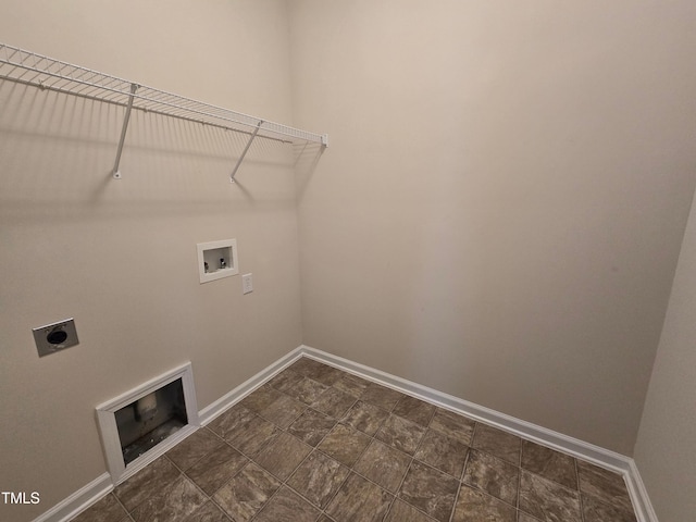 laundry room featuring hookup for a washing machine, electric dryer hookup, baseboards, and stone finish floors