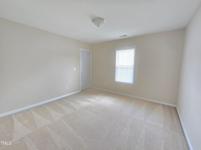 unfurnished room featuring baseboards and light colored carpet