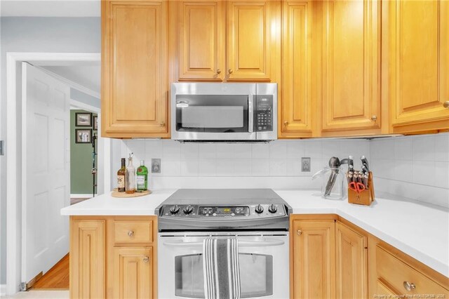 503 Charleston Pl, Fayetteville, NC 28303 - kitchen featuring appliances with stainless steel finishes, decorative backsplash, light countertops, ornamental molding, and light brown cabinets