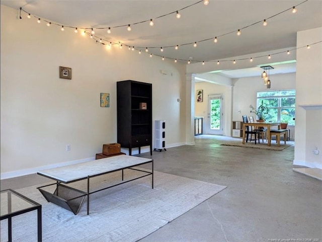 living room with concrete floors and baseboards