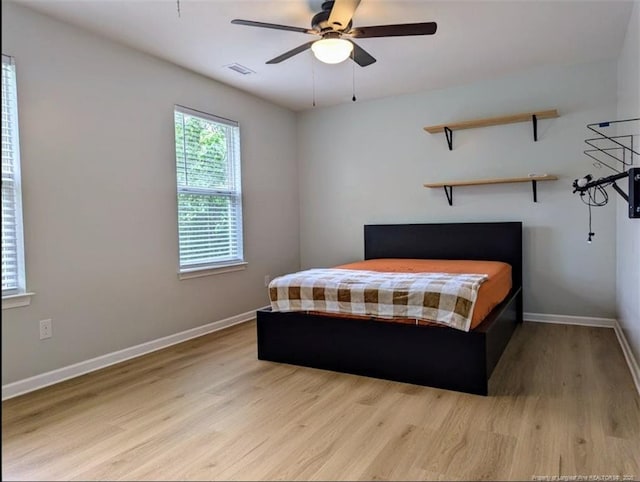 bedroom featuring light wood finished floors, baseboards, and ceiling fan