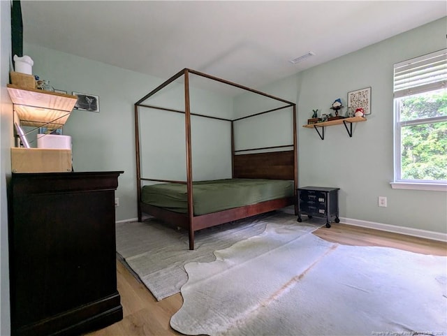 bedroom featuring wood finished floors and baseboards