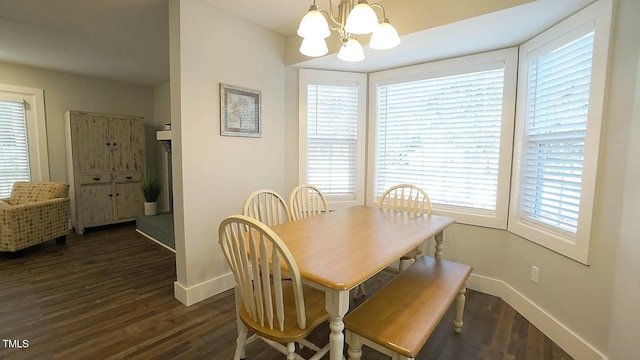 dining space with baseboards, a chandelier, and dark wood-style floors