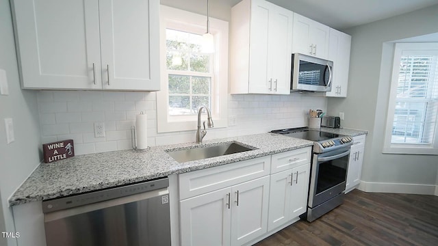 kitchen with stainless steel appliances, a sink, dark wood-style flooring, and healthy amount of natural light
