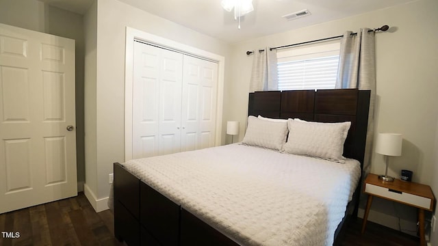 bedroom featuring a closet, dark wood-type flooring, and baseboards