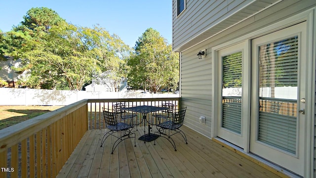 wooden deck featuring outdoor dining area and fence