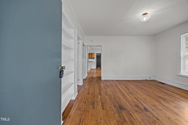 303 N Watauga Ave, Dunn, NC 28334 - spare room with wood-type flooring, built in shelves, and crown molding